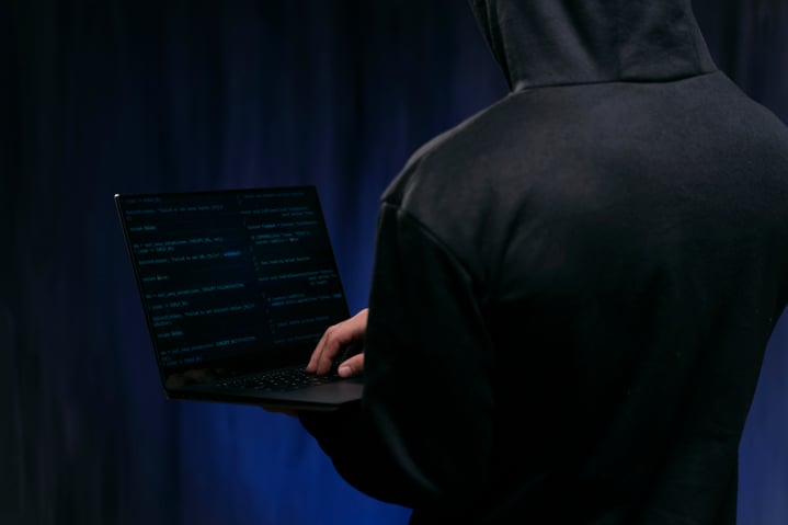 close-up-hacker-holding-laptop